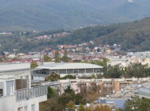 U sredini slike je Shopping centar Prečko, a iza njega zgrade Španskog i Malešnice, pošumljeno brdo desno je Grmoščica. [VR 2023.]